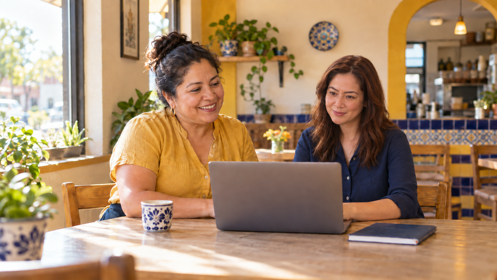 Escena ilustrativa de una dueña de restaurante y una diseñadora web revisando una computadora juntas.